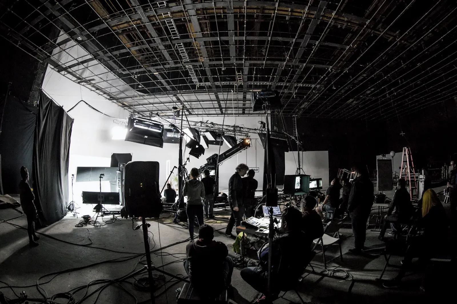 Filmteam riggar ljus och kamera i en stor studio