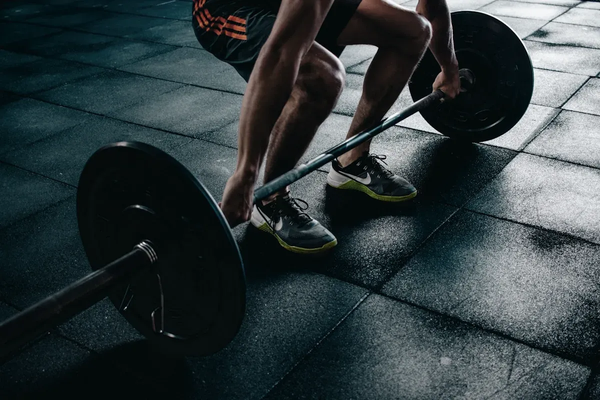 Skivstång på gymgolvet, fötter i position för ett marklyft